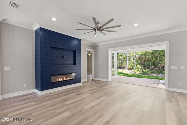 unfurnished living room with ceiling fan, ornamental molding, light hardwood / wood-style flooring, and a fireplace