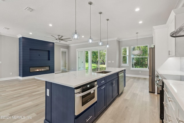 kitchen featuring an island with sink, sink, light hardwood / wood-style flooring, and white cabinetry