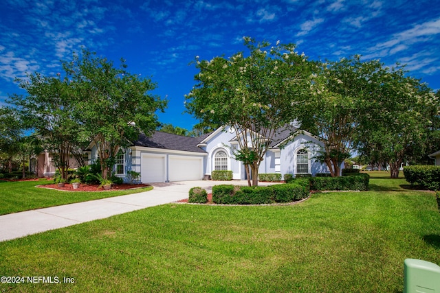 view of front of house with a garage, concrete driveway, a front lawn, and stucco siding