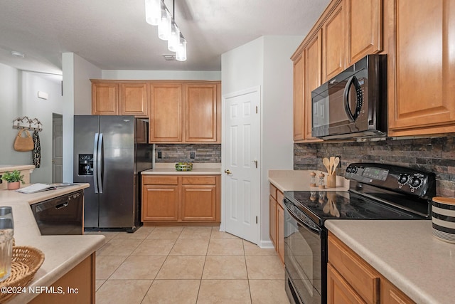 kitchen featuring backsplash, track lighting, black appliances, hanging light fixtures, and light tile patterned flooring