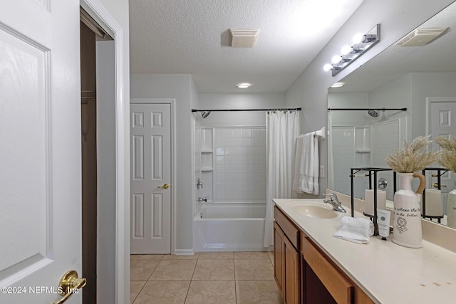 bathroom with a textured ceiling, vanity, tile patterned floors, and shower / bathtub combination with curtain