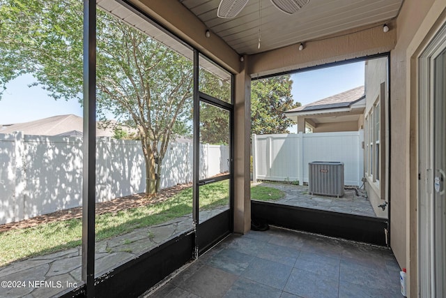 unfurnished sunroom with ceiling fan