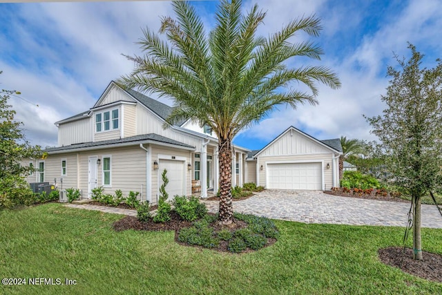 view of front of house with a garage, central AC unit, decorative driveway, and a front yard