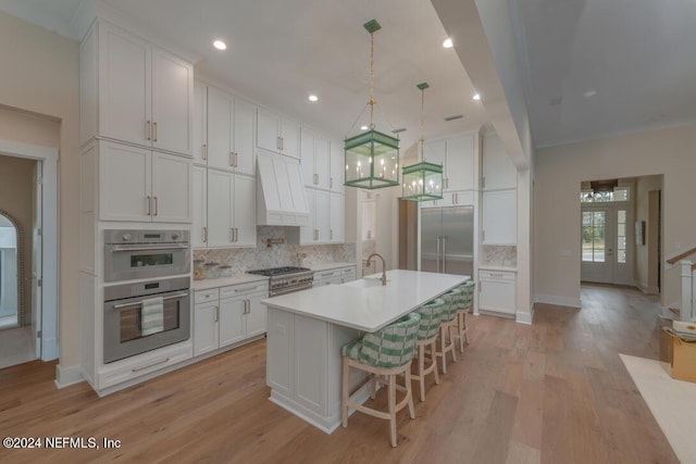 kitchen featuring stainless steel appliances, white cabinets, light countertops, backsplash, and custom exhaust hood