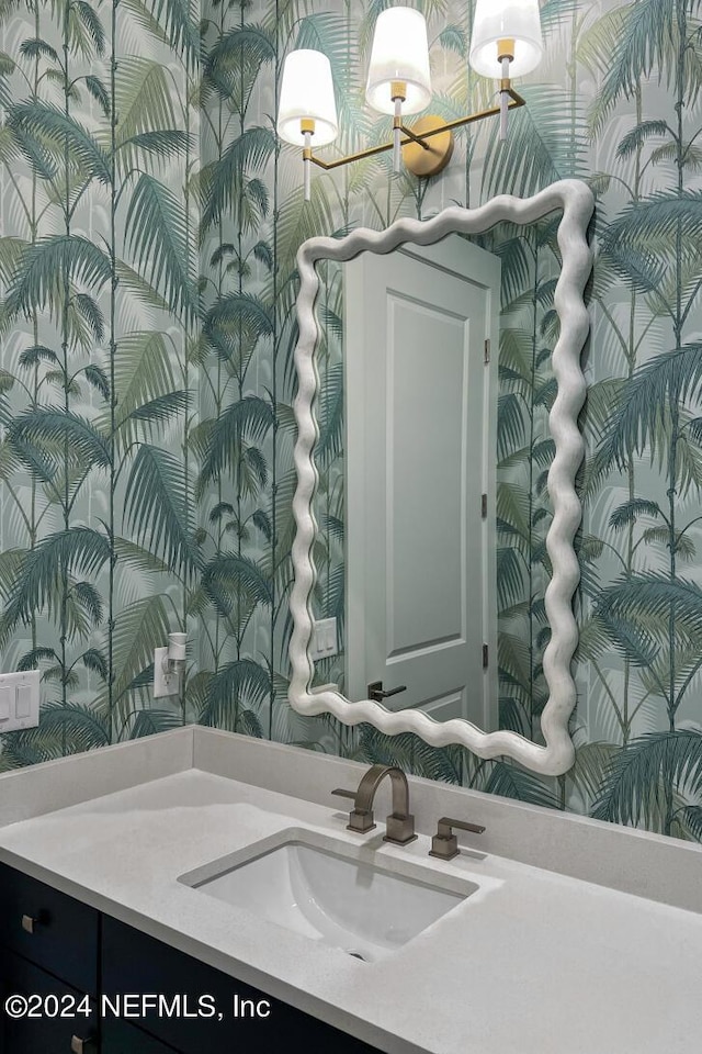 bathroom with vanity and wallpapered walls