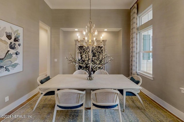 dining room featuring a notable chandelier, baseboards, and wood finished floors