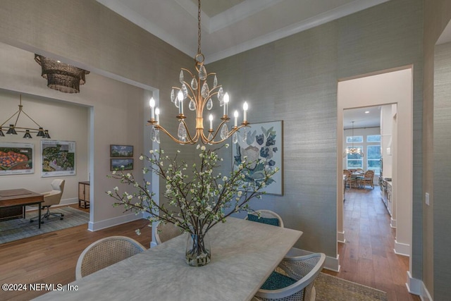 dining space with wood finished floors, a high ceiling, baseboards, and an inviting chandelier