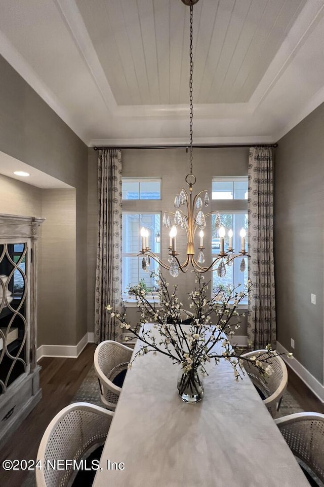 dining space with wood finished floors, a raised ceiling, and baseboards