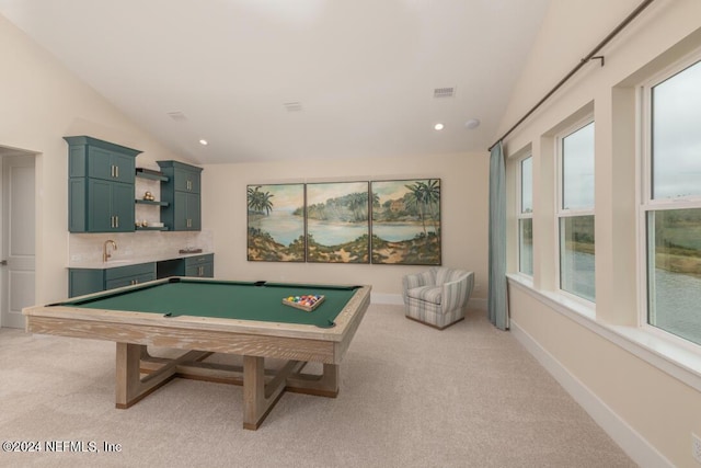 game room with baseboards, vaulted ceiling, indoor wet bar, and light colored carpet