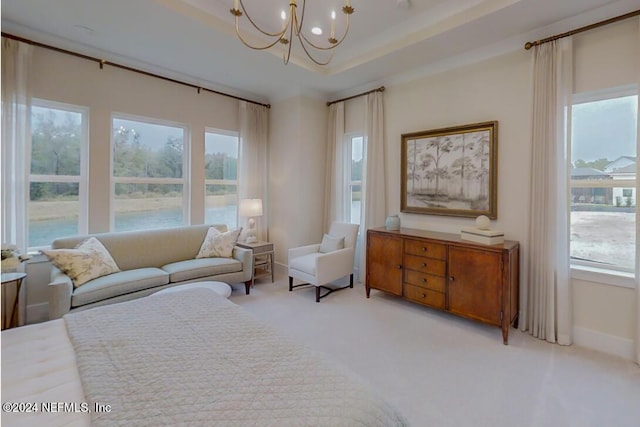 bedroom with baseboards, a chandelier, a raised ceiling, and light colored carpet