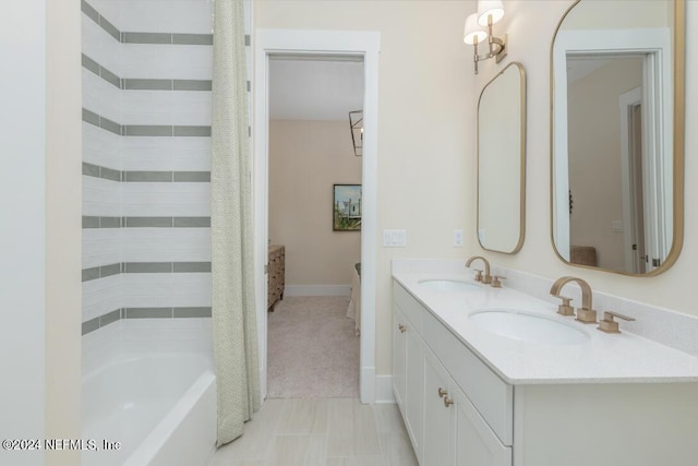 bathroom featuring double vanity, a sink, and baseboards