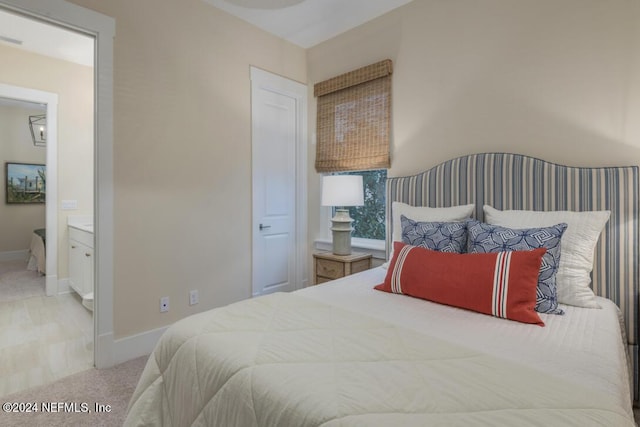 bedroom with baseboards, carpet flooring, and ensuite bathroom