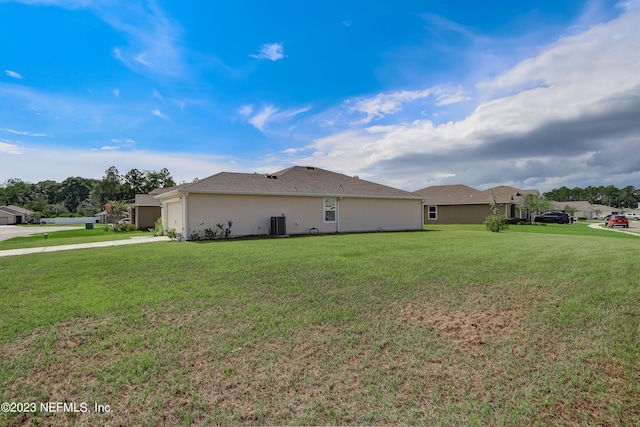 view of side of home featuring a lawn and central AC