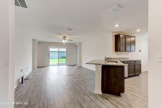 kitchen with ceiling fan, light wood-type flooring, light stone countertops, dark brown cabinets, and kitchen peninsula