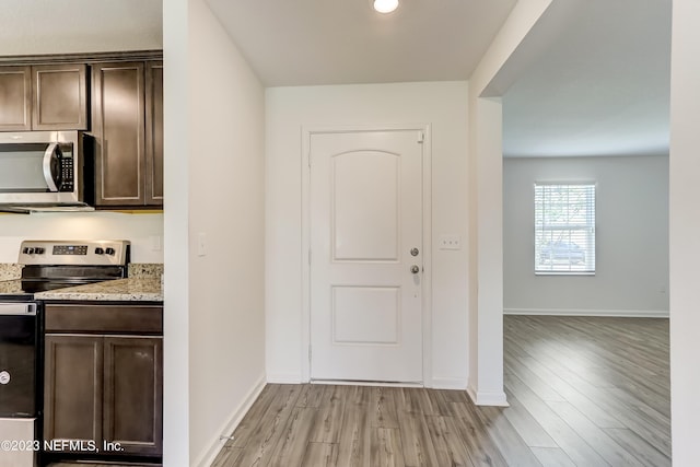 kitchen with light wood-type flooring, dark brown cabinetry, and stainless steel appliances