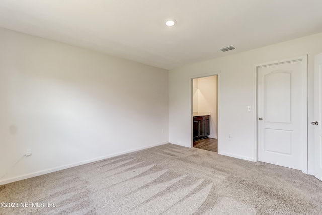 unfurnished bedroom with carpet floors and ensuite bath