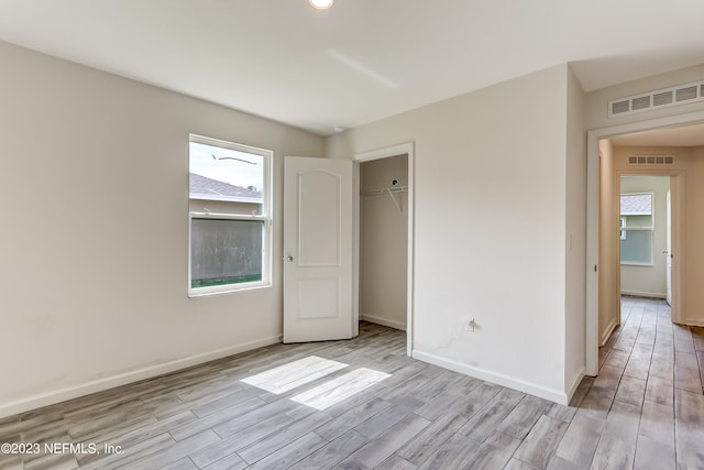 unfurnished bedroom featuring light hardwood / wood-style floors and a closet