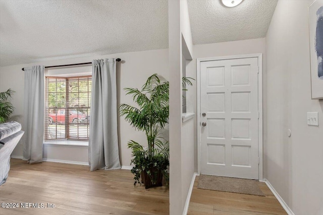 entrance foyer featuring a textured ceiling and light hardwood / wood-style flooring