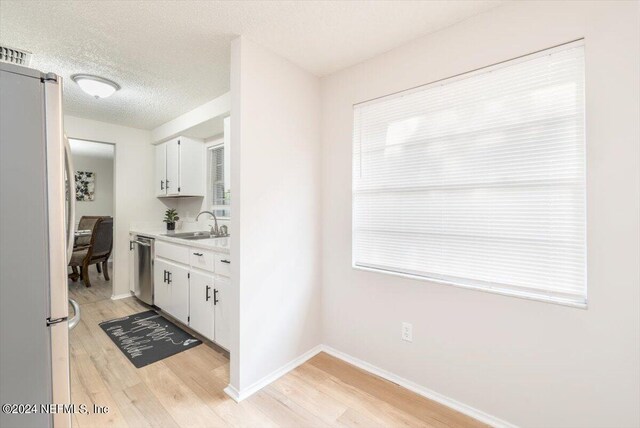 kitchen featuring white refrigerator, white cabinets, dishwasher, and light hardwood / wood-style flooring