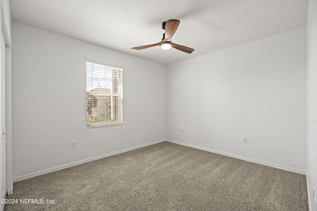 carpeted spare room featuring ceiling fan and a textured ceiling