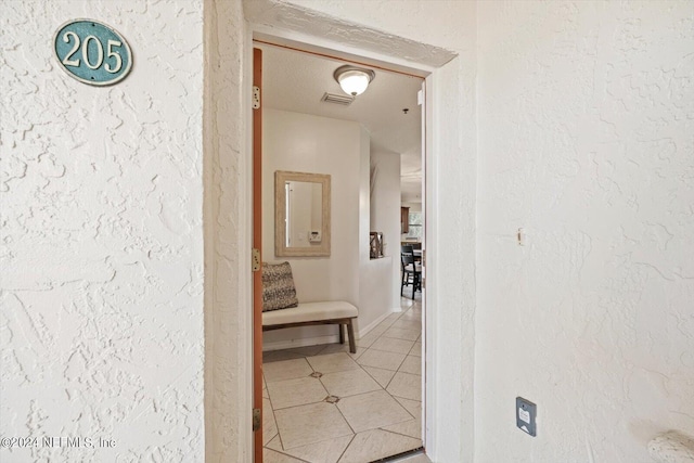 corridor featuring tile patterned floors and a textured ceiling