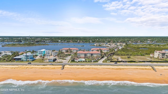 bird's eye view featuring a water view and a beach view