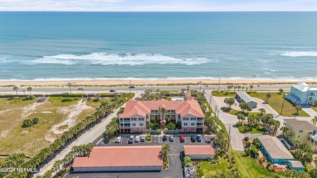 drone / aerial view featuring a water view and a view of the beach