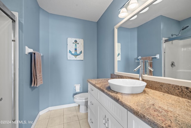 bathroom featuring tile patterned flooring, a textured ceiling, toilet, vanity, and a shower with shower door