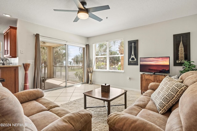 tiled living room with ceiling fan, sink, and a textured ceiling