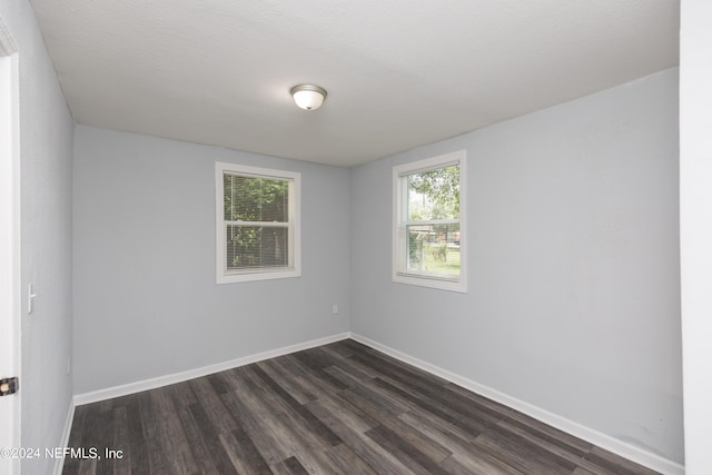 unfurnished room featuring dark hardwood / wood-style flooring and a textured ceiling