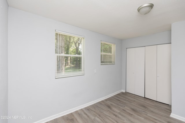 unfurnished bedroom with a closet and light hardwood / wood-style flooring