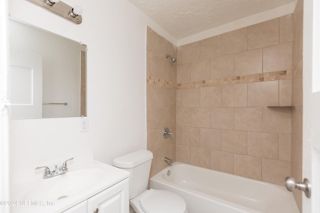 full bathroom featuring tiled shower / bath combo, toilet, a textured ceiling, and vanity