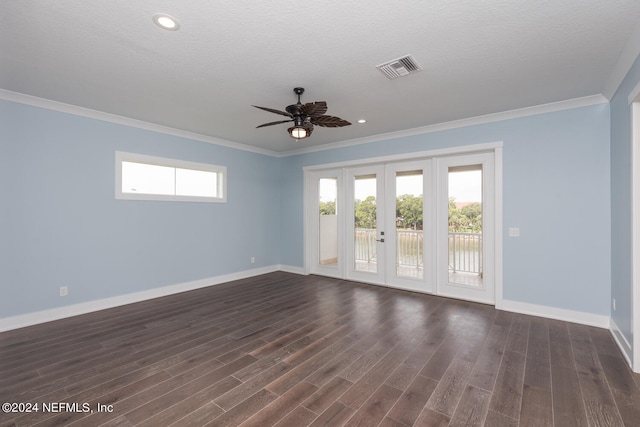 empty room with visible vents, dark wood finished floors, and a wealth of natural light