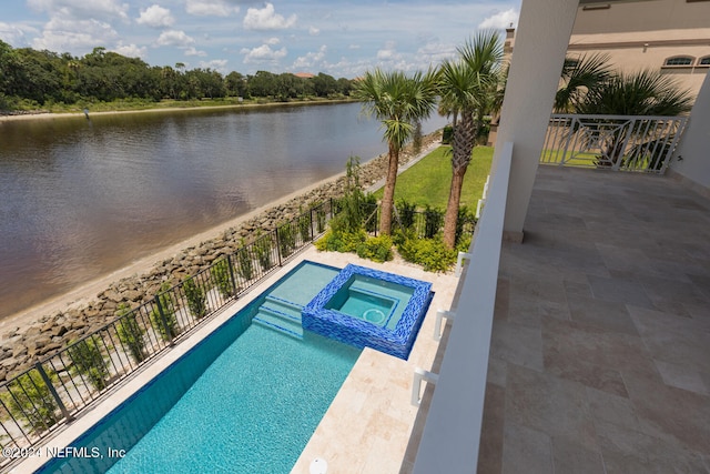 view of swimming pool with a water view and a pool with connected hot tub