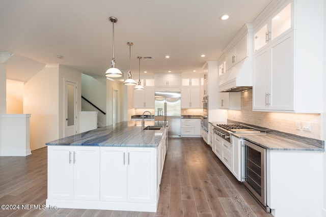 kitchen featuring wine cooler, a center island with sink, and white cabinetry