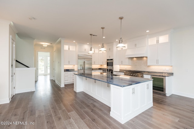 kitchen with wine cooler, a center island with sink, white cabinets, and appliances with stainless steel finishes