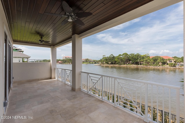 view of patio / terrace with a water view, a balcony, and ceiling fan