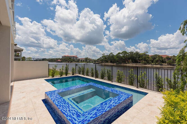 view of pool with a patio area, a pool with connected hot tub, and fence