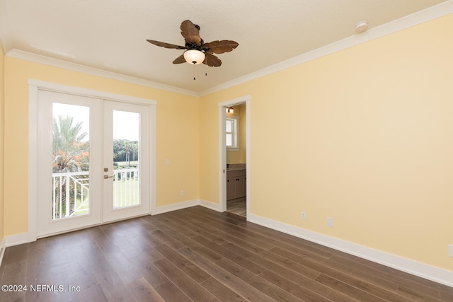 empty room with crown molding, dark wood finished floors, and a wealth of natural light