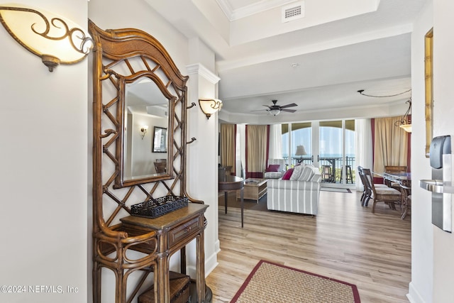 living room with ceiling fan, ornamental molding, and light hardwood / wood-style floors