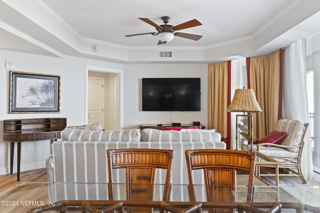 living room with ornamental molding, ceiling fan, and light hardwood / wood-style flooring