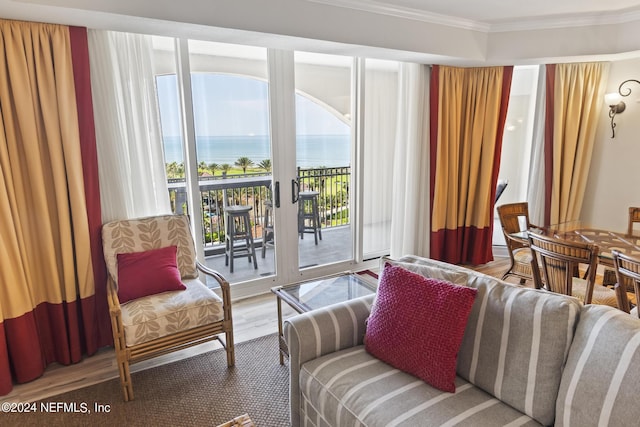 living room featuring hardwood / wood-style floors, crown molding, and a water view