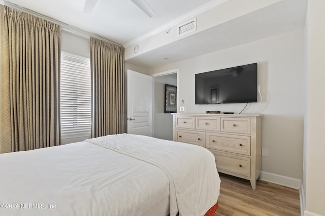 bedroom featuring crown molding, light hardwood / wood-style floors, and ceiling fan