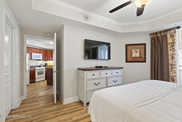 bedroom featuring ceiling fan, ornamental molding, a raised ceiling, and light hardwood / wood-style flooring