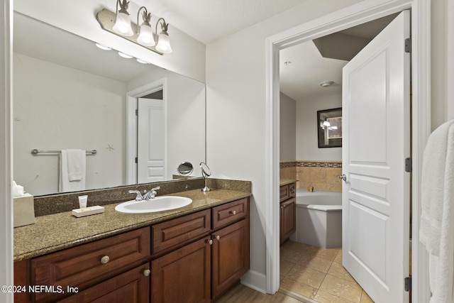 bathroom featuring tile patterned floors, vanity, and a tub