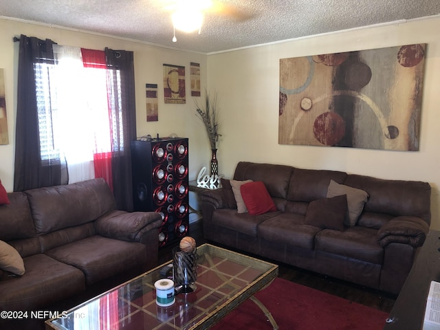 living room featuring a textured ceiling, crown molding, and ceiling fan