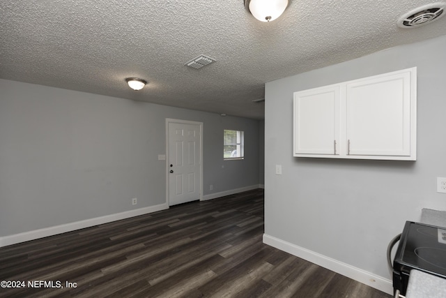 interior space featuring a textured ceiling and dark hardwood / wood-style flooring