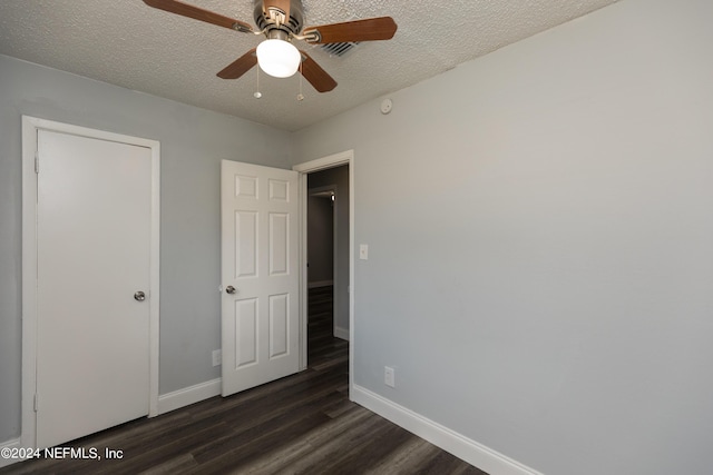 unfurnished bedroom with ceiling fan, dark hardwood / wood-style floors, and a textured ceiling