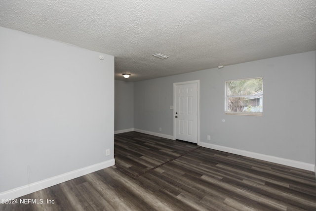 spare room with dark wood-type flooring and a textured ceiling