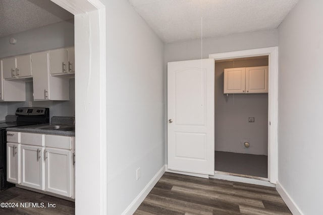 kitchen featuring black electric range oven, a textured ceiling, dark hardwood / wood-style floors, and white cabinets